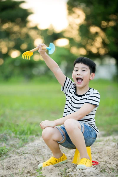 Asyalı çocuk Bahçe oyuncakları ile oynarken — Stok fotoğraf