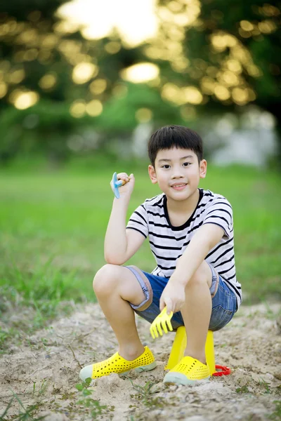 Asiatico ragazzo giocare con giocattoli in giardino — Foto Stock