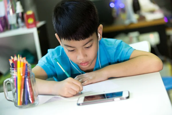 亚洲男孩使用手机和在一张白纸上作画 — 图库照片