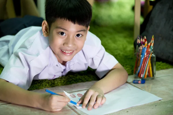 Asiatiska barn i student uniform målning på ett vitt papper — Stockfoto