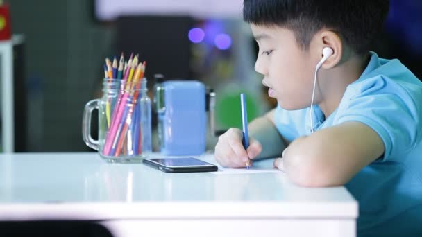 Ασιατικές παιδί με μια ψηφιακή δισκίο με μπουμπούκια αυτί για το έξυπνο τηλέφωνο. — Αρχείο Βίντεο