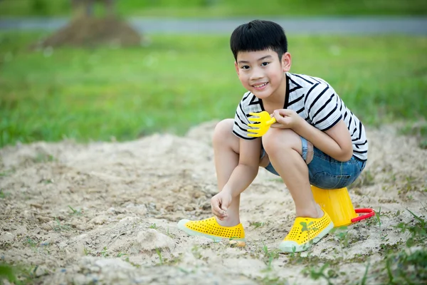 Asiatische Niedlich junge spielen mit Spielzeug in Garten — Stockfoto