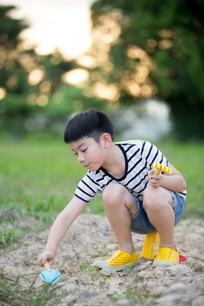 アジアのかわいい男の子が庭でおもちゃで遊んで — ストック写真