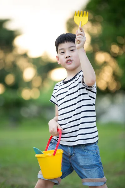 Asian söt pojke leker med leksaker i trädgården — Stockfoto