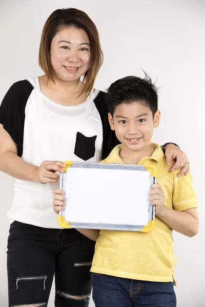 Asiático mãe e filho com placa branca em branco e olhando câmera — Fotografia de Stock