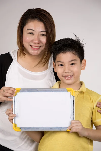 Asiatisch mutter und sohn mit blank white board und looking camera — Stockfoto