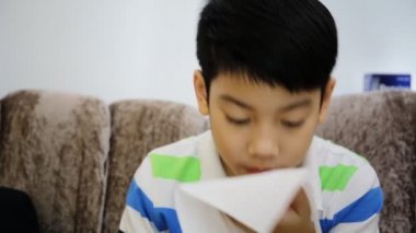 Küçük Asyalı çocuk hasta gribi hapşırma ile ve temiz kağıt mendil ile