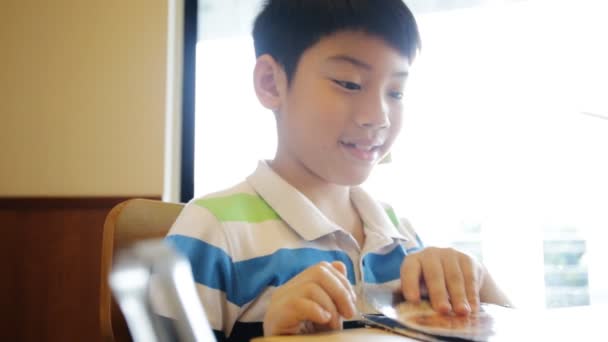 Happy Asian cute boy reading menu book and point . — Stock Video