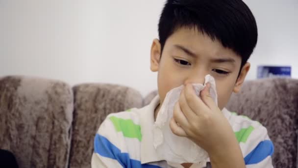 Маленький азиатский ребенок, больной гриппом чихает и чистит салфеткой — стоковое видео