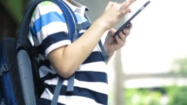 Asyalı çocuk dijital cep telefonu kullanma sırt çantası ile