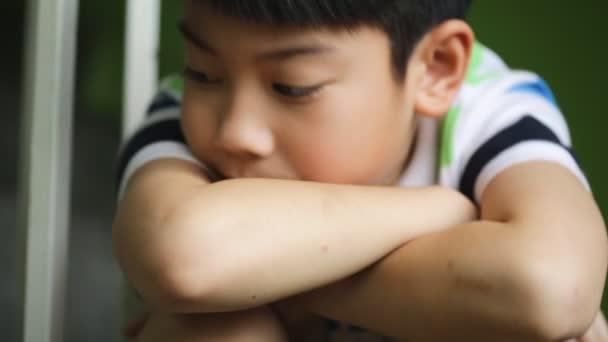 Tristeza asiático niño sentarse y deprimido, inclinar hasta cámara — Vídeos de Stock