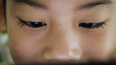 Asyalı çocuk dijital bir cep telefonu kullanarak yakın çekim