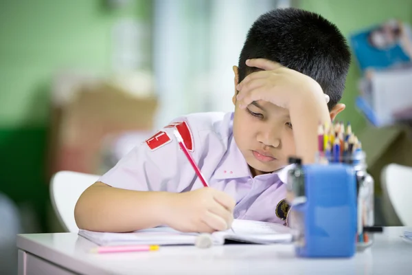 Giovane asiatico ragazzo doing suo homework — Foto Stock