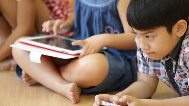 Grupo de niños asiáticos jugando juntos con una tableta de computadora  . — Vídeo de stock