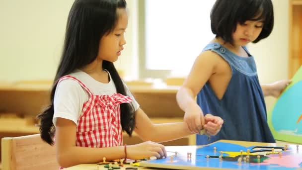 Kleines asiatisches Mädchen sucht Südostasien nach einem Puzzle auf einer geografischen Karte — Stockvideo