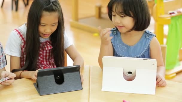 Skupina malých asijských dětí, které hrají společně s počítačovým tabletem . — Stock video