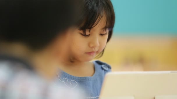 Aziatische kindje spelen met een tablet-computer . — Stockvideo