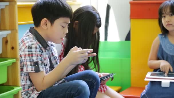 Gruppe kleiner asiatischer Kinder spielt zusammen mit einem Computer-Tablet . — Stockvideo