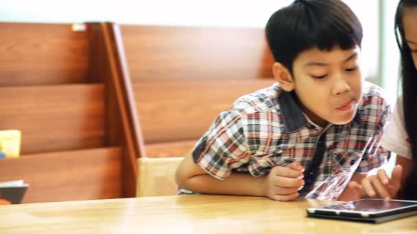 Aziatische kinderen die een digitale Tablet samen gebruiken . — Stockvideo