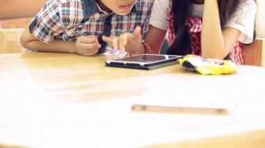 Birlikte dijital tablet kullanan Asyalı çocuklar .