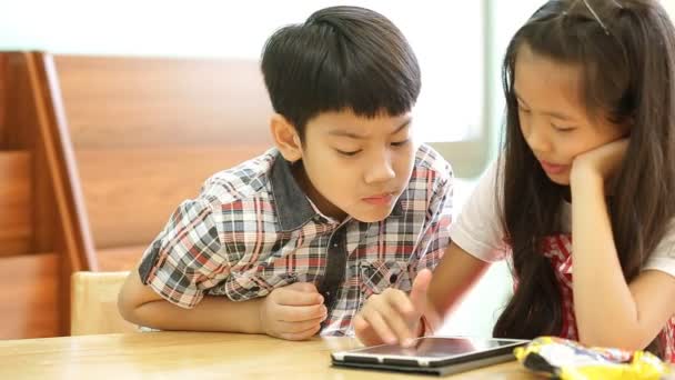 Aziatische kinderen die een digitale Tablet samen gebruiken . — Stockvideo