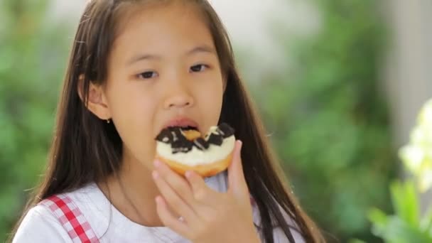 Piccolo asiatico bambino mangiare ciambella dolce cibo — Video Stock