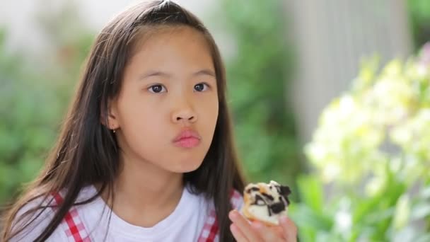 Lilla asiatiska barn äta donut söt mat — Stockvideo