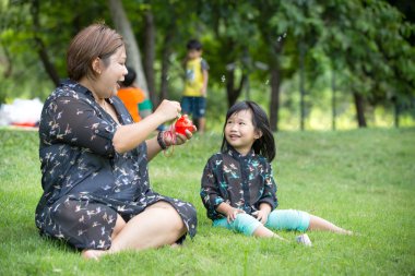 Mutlu Asya anne ve kızı iblowing sabun köpüğü 