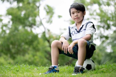 Küçük Asyalı çocuk parkta futbol ile