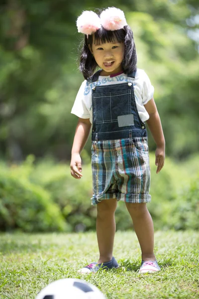 Piccola ragazza asiatica che gioca a calcio al parco — Foto Stock