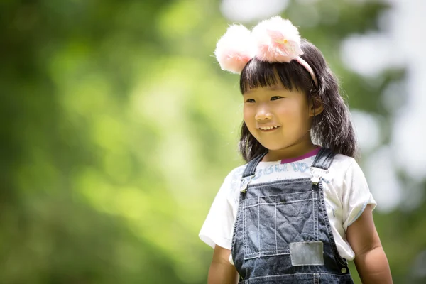 Retrato de menina asiática no parque verde fundo , — Fotografia de Stock