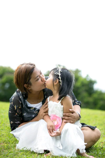 Мать-азиатка целует его дочь в парке. — стоковое фото