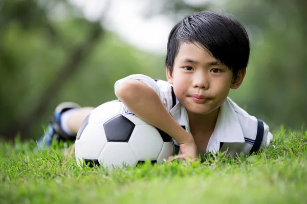 Mały azjatycki chłopiec z piłki nożnej w parku — Zdjęcie stockowe