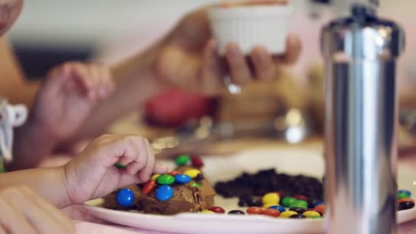 Nahaufnahme Hand eines kleinen Jungen Kleinkind macht Schokoladenkekse mit seiner schwangeren Mutter . — Stockvideo