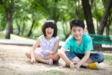 Küçük Asyalı çocuk parkta oynarken kuma