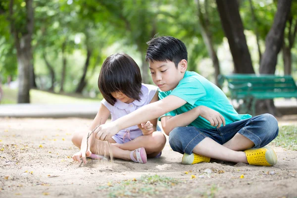 在公园里的小亚洲儿童玩沙子 — 图库照片