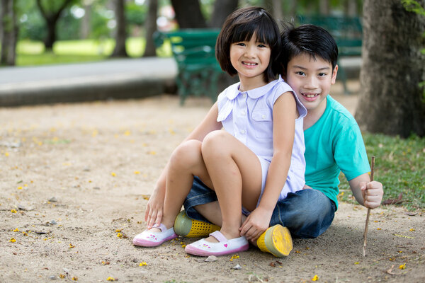Маленький азиатский ребенок играет в песок в парке

