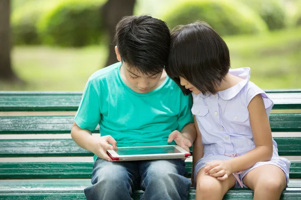 Petit Asiatiquegarçon et fille jouent ensemble avec un ordinateur ta — Photo