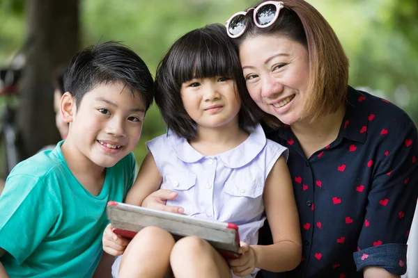 Famille asiatique jouent ensemble avec une tablette d'ordinateur dans le — Photo