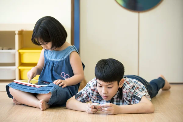 Pequeno menino e menina asiática estão jogando junto com um computador t — Fotografia de Stock