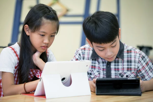 Kis-ázsiai fiú és lány játszik együtt a számítógép-t — Stock Fotó