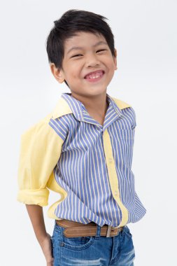 Küçük Asyalı çocuk gri arka yüzünde bir gülümseme ile