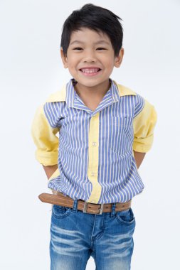 Küçük Asyalı çocuk gri arka yüzünde bir gülümseme ile