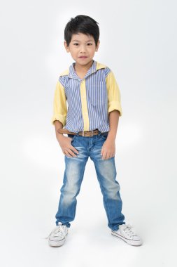 Küçük Asyalı çocuk gri arka yüzünde bir gülümseme ile