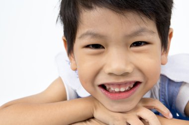 Küçük Asyalı çocuk gri arka yüzünde bir gülümseme ile