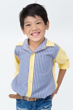 Küçük Asyalı çocuk gri arka yüzünde bir gülümseme ile