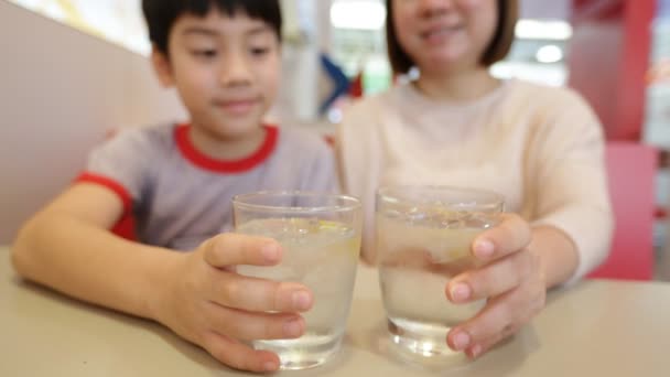 亚洲的幸福母亲和她的孩子喝水，微笑的脸 — 图库视频影像