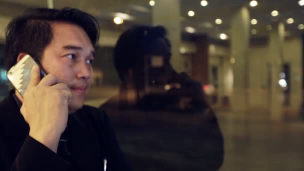 Hombre de negocios asiático utilizando en el teléfono móvil y el uso de teléfono inteligente en la noche en la cafetería. Hombre guapo esperando a alguien, Bangkok Tailandia — Vídeo de stock