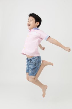 Stüdyoda mutlu Asya oğlan atlıyor.