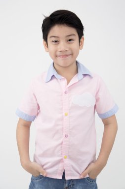 Küçük Asyalı çocuk gri arka yüzünde bir gülümseme ile